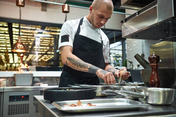 istock Important ingredient. Concentrated young chef breaking an egg for traditional italian pasta while standing in a restaurant kitchen 1136639106