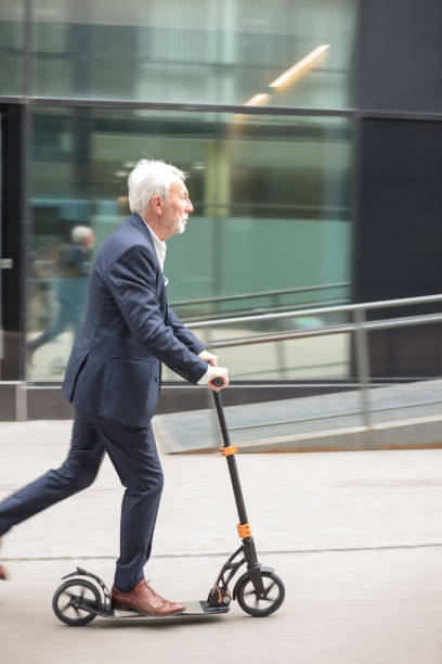 istock Serious senior businessman commuting to work on a push scooter 1136639151