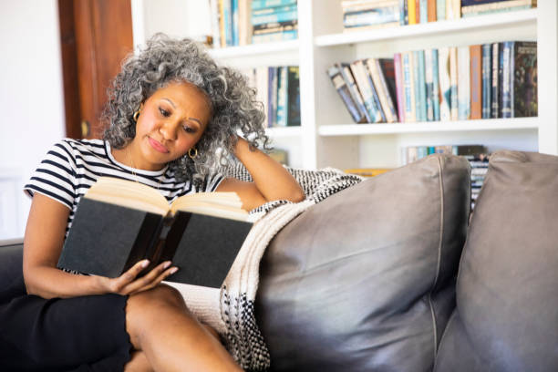 istock Black Woman Reading a book in her library at home 1136639295
