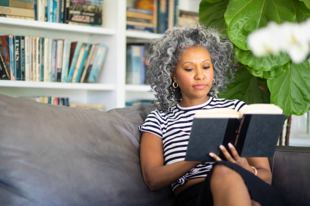 istock Black Woman Reading a book in her library at home 1136639370
