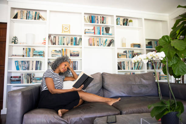 istock Black Woman Reading a book in her library at home 1136639419