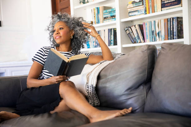 istock Black Woman Reading a book in her library at home 1136639465