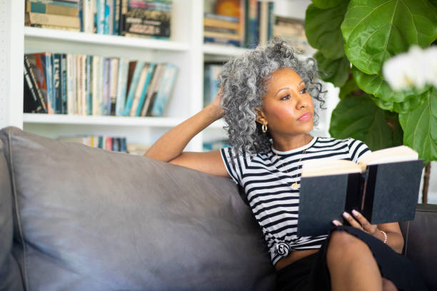 istock Black Woman Reading a book in her library at home 1136639542