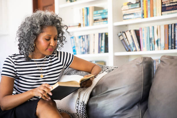 istock Black Woman Reading a book in her library at home 1136639571
