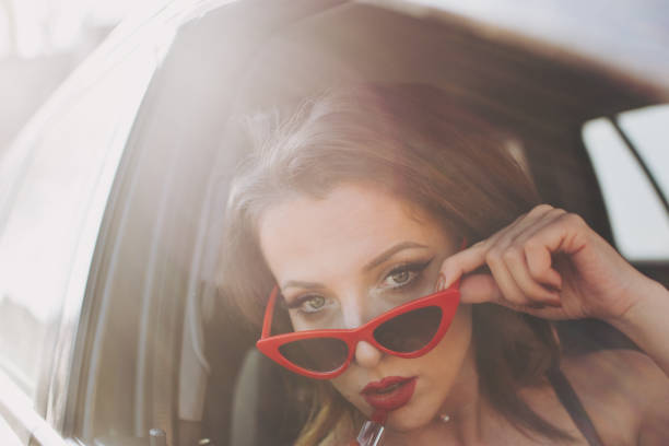 istock Beautiful female Driver applying lipstick 1136639631
