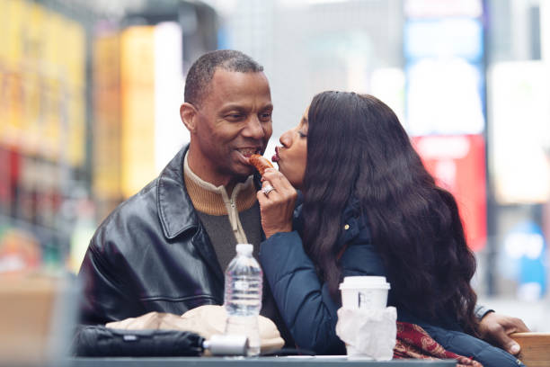 couple mûr dans time square - couple black american culture kissing photos et images de collection