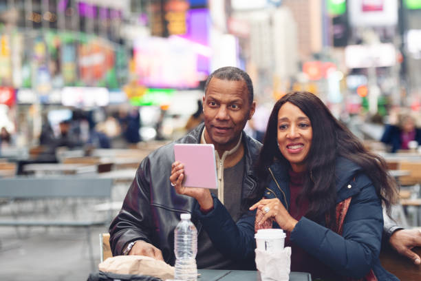 couple mûr dans time square - couple black american culture kissing photos et images de collection