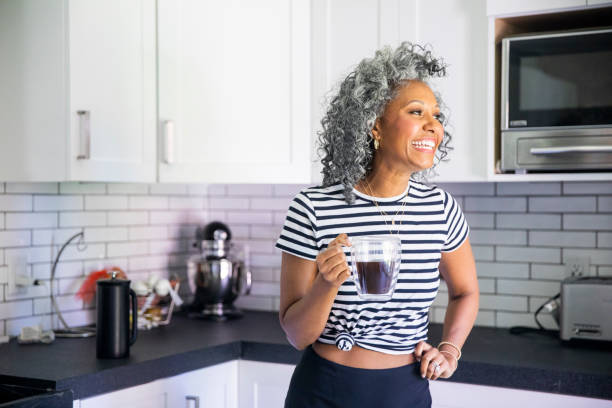 istock Mature Black woman Drinking Coffee in Bright Modern Kitchen 1136641050