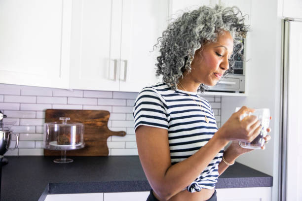 istock Mature Black woman Drinking Coffee in Bright Modern Kitchen 1136641112