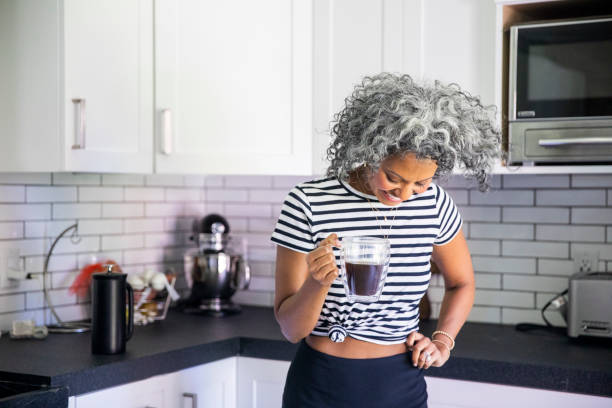 istock Mature Black woman Drinking Coffee in Bright Modern Kitchen 1136641207