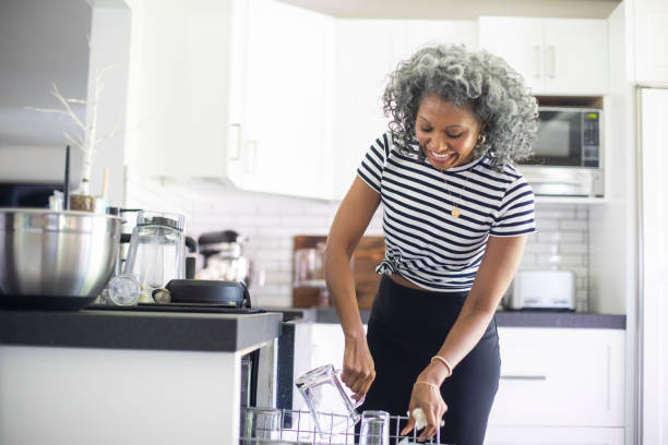 istock Mature Black Woman Loading Dishwasher 1136641352