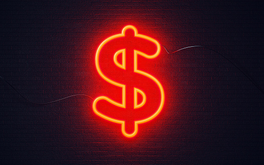 American Dollar sign shaped red neon light on black wall. Horizontal composition with copy space. Great use for currency exchange concepts.