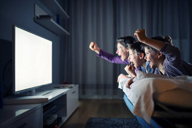 テレビを見て応援する3人の子供たち - bed cheerful enjoyment excitement ストックフォトと画像