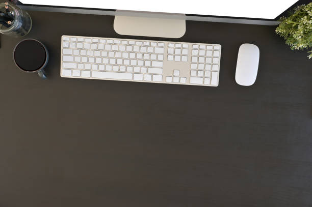 istock Office desk top view computer and office supplies above of black table. 1136642722