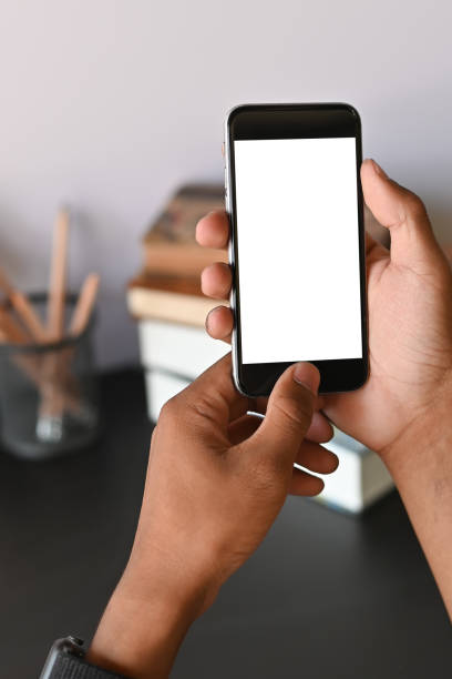 istock Cropped shot of smartphone on hands with empty screen on office desk. 1136642797