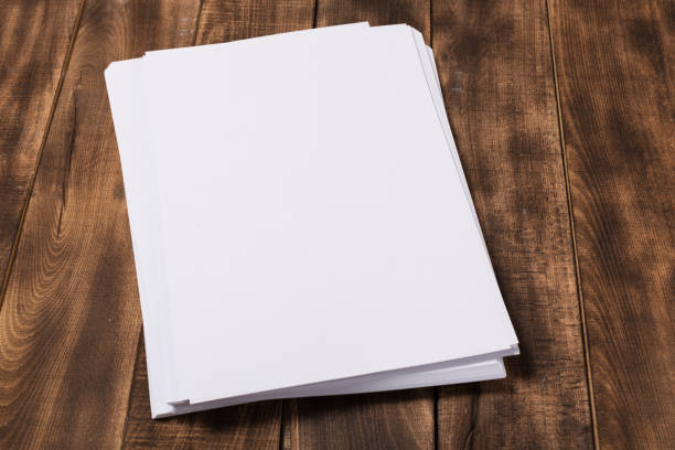 istock Blank paper notebook on brown wooden table background. Top view with copy space 1136645782