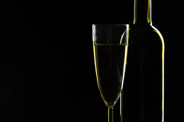 istock elegant wine bottles and wine glass in a black background 1136645857