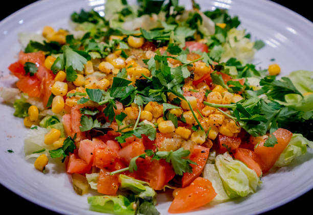 istock Fresh vegetable salad in a plate isolated on black background 1136647399
