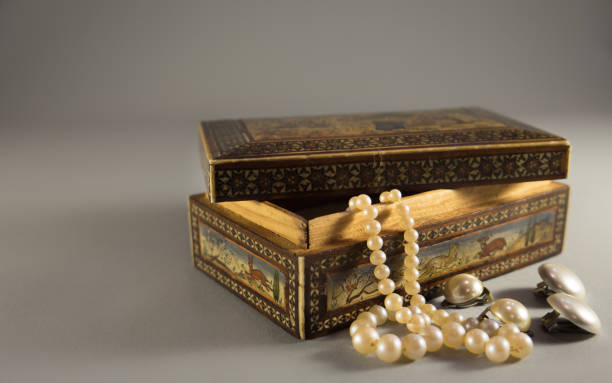 старый деревянный корпус драгоценности с красивыми орнаментами, белые зажимы для ушей жемчуга и ожерелье - jewelry antique pearl gem стоковые фото и изображения