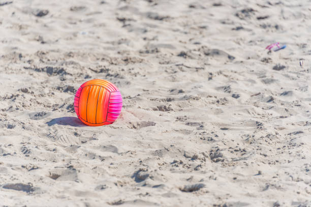 istock Bright Beach Ball on a Sandy Beach on a Sunny Day 1136651400