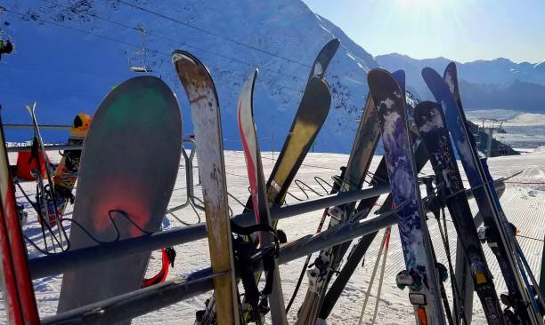 esquís, polacos y snowboards en un estante en la parte superior de una zona de remonte en invierno - girdwood fotografías e imágenes de stock