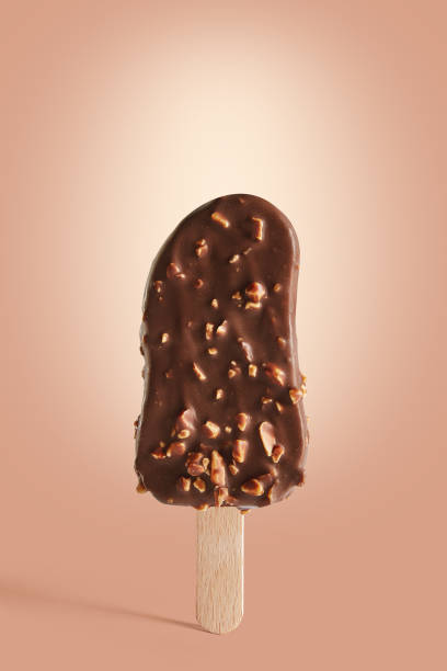 istock Chocolate coated ice cream on a stick on a brown background. 1136653672