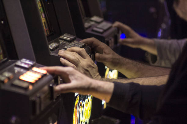 istock Gambling hands on slot machines 1136653771