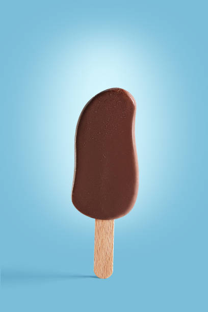 istock Chocolate coated ice cream on a stick on a blue background. 1136653860