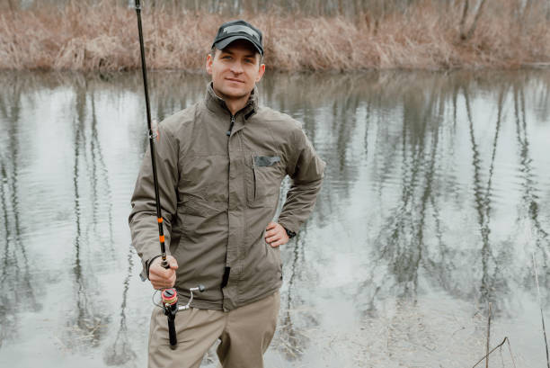 istock Young man standing with fishing rod 1136654670