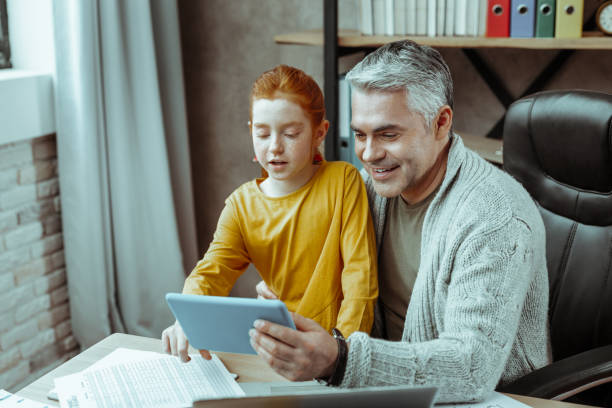 istock Positive cheerful man looking at the tablet screen 1136654752