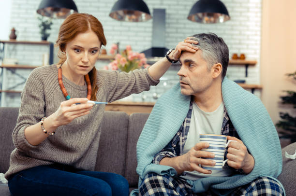istock Nice worried woman looking at the electronic thermometer 1136655058