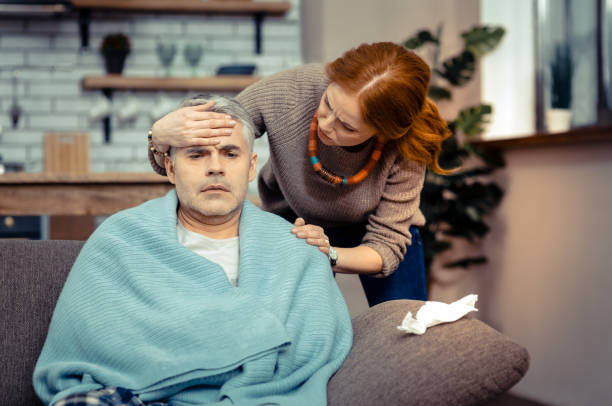 istock Pleasant anxious woman feeling her husbands temperature 1136655131