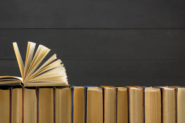 istock Open book, hardback books on wooden table. Back to school. Copy space. 1136656100