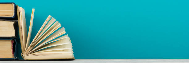 istock Open book, hardback books on wooden table. Back to school. Copy space. 1136656155