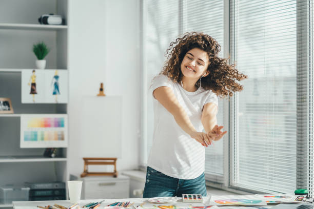 a dança feliz da mulher perto da tabela com retratos - watercolor paper audio - fotografias e filmes do acervo