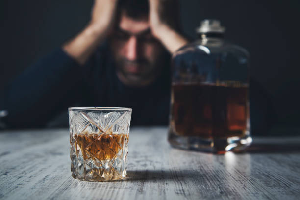 istock sad man hand in head with whiskey 1136658151