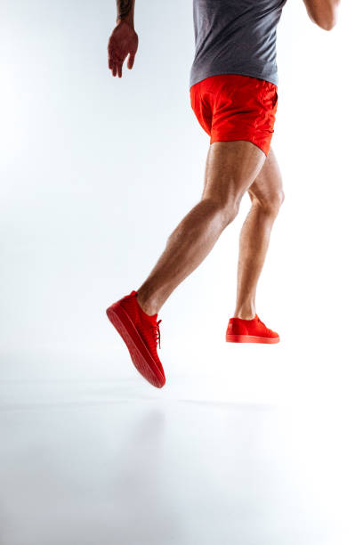 istock Sportive man in red shorts and snickers doing running movements 1136658306