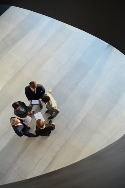 istock Group of office workers with papers in hall 1136660124