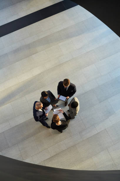 istock Group of businesspeople talking in hallway 1136660670
