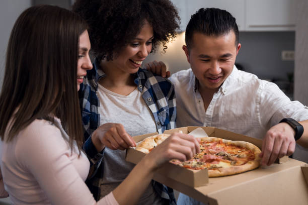 istock Friends eating pizza at home 1136661471