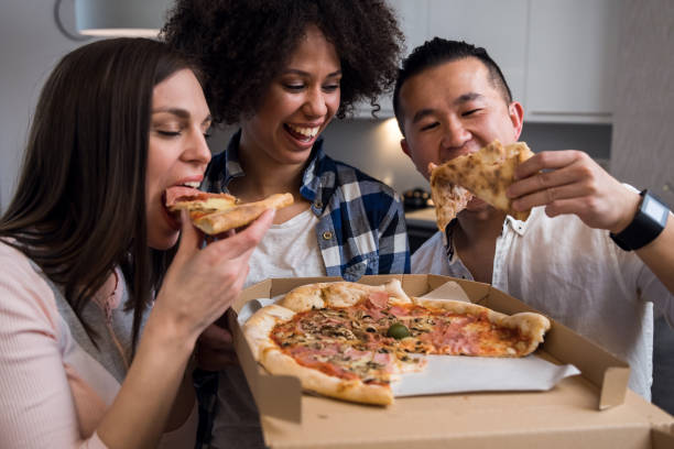 istock Friends eating pizza at home 1136661587