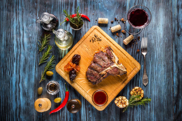 istock Medium rare grilled t-bone steak on rustic wooden background with rosemary and spices 1136661636