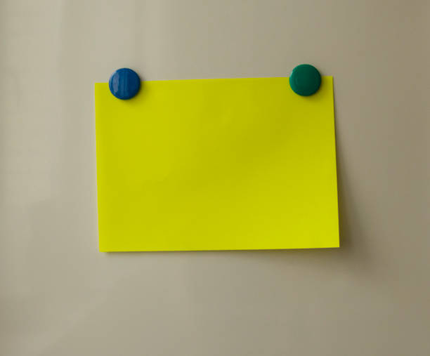 istock Yellow blank note on beige background, green and blue magnets 1136666788