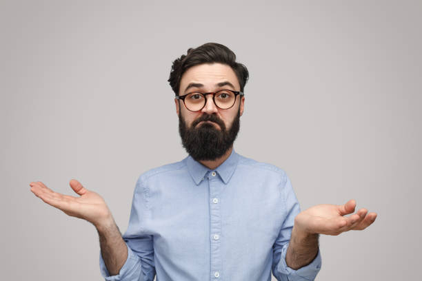 istock Doubtful bearded man shrugging with shoulders 1136668068