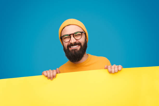 istock Hipster holding heavy banner with grimace 1136668120