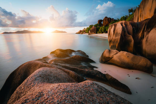 Dreamy sunset at the gorgeous exotic Anse Source d'Argent beach, La Digue island, Seychelles. Long exposure panorama.