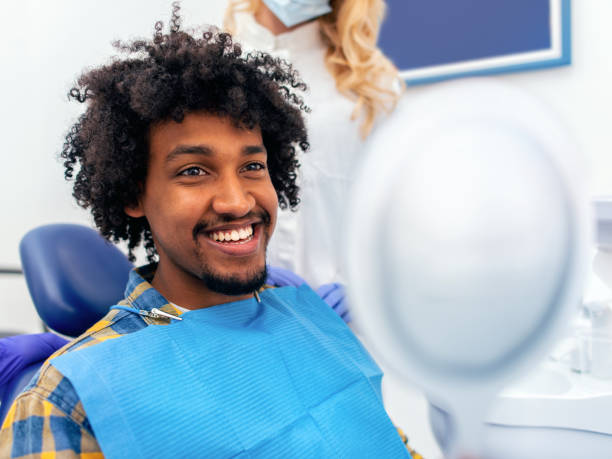 dentist showing patient his new smile in the mirror - dental light dental equipment hospital professional occupation imagens e fotografias de stock