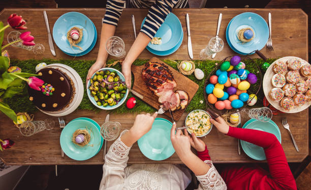 Easter Table Overhead view on decorated Easter table with family around easter cake photos stock pictures, royalty-free photos & images