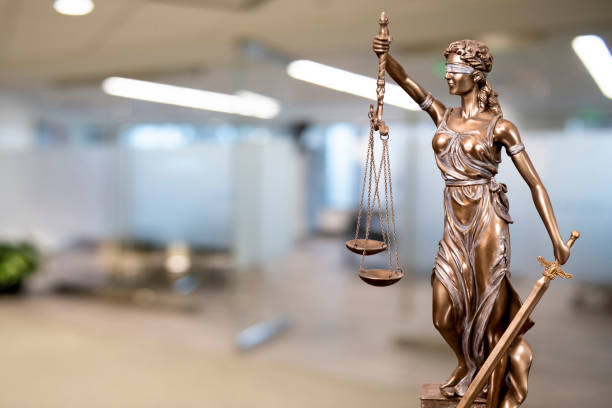 Lady Justice Statue with Defocused Office Background Lady Justice statue made of bronze holding the scales suggesting fairness in law stands guard in the foyer of a conference room. lady justice photos stock pictures, royalty-free photos & images