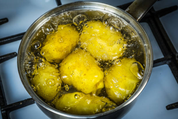 istock potatoes boil in water and a saucepan. place for your text. 1136676936